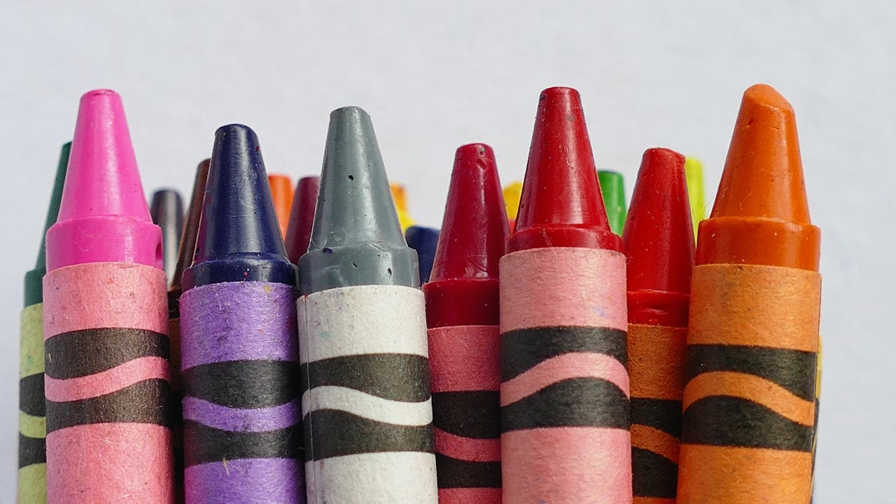 A vibrant collection of colorful crayons arranged in a row, perfect for arts and crafts.